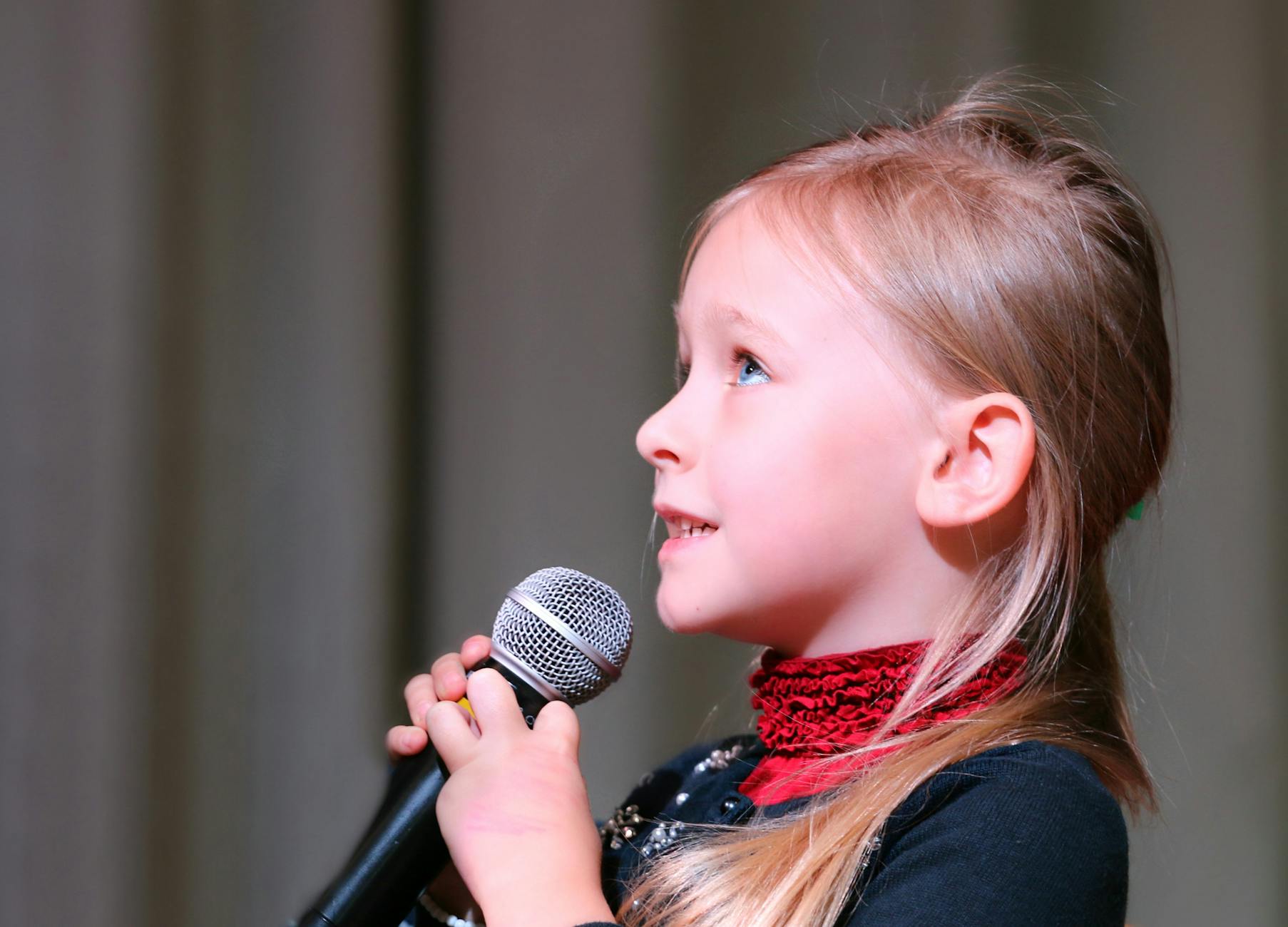 girl holding black dynamic microphone while looking above