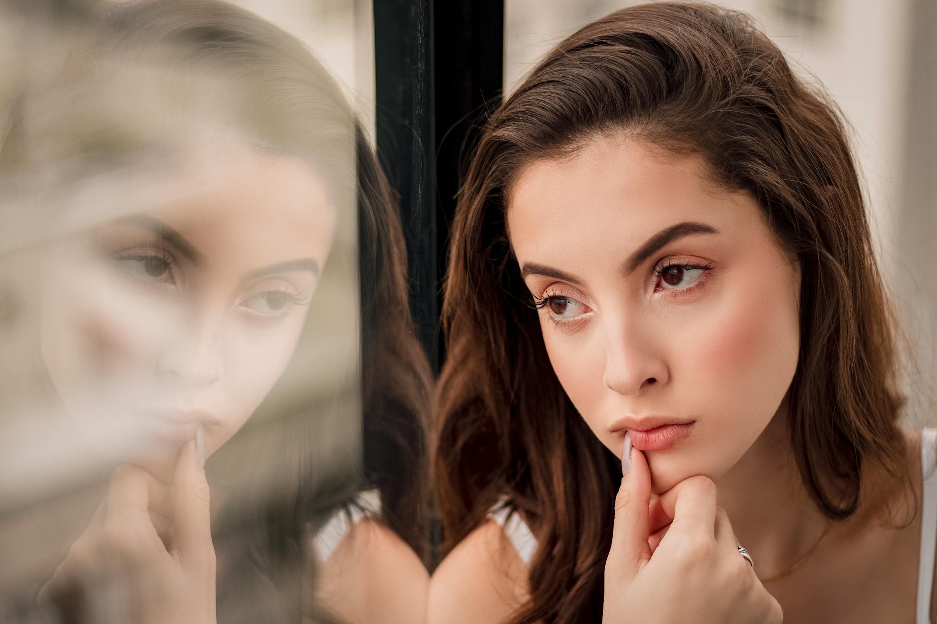 close up portrait photo of woman sitting by window looking outside