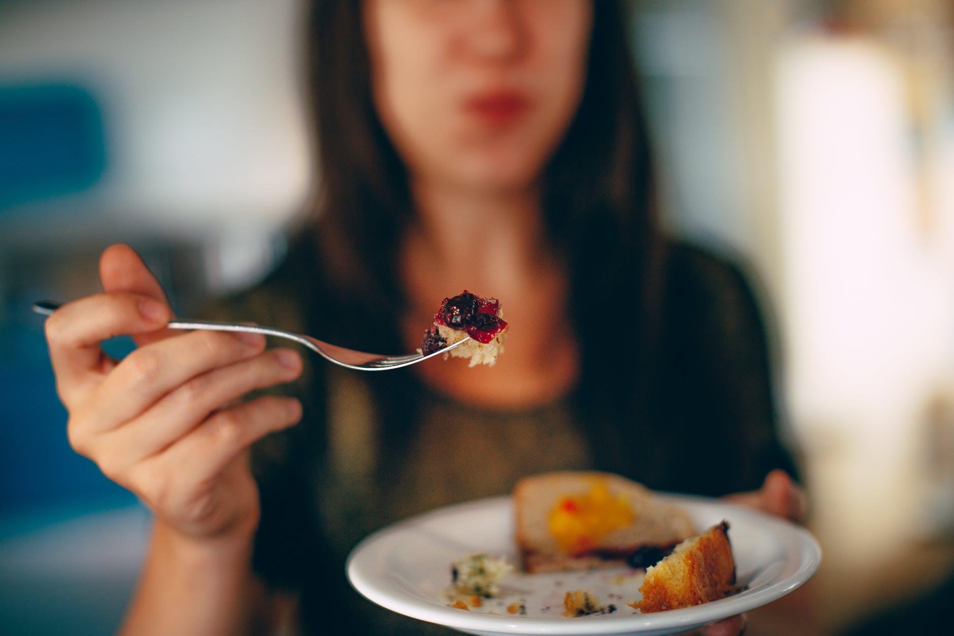 crop woman eating delicious pie in plate