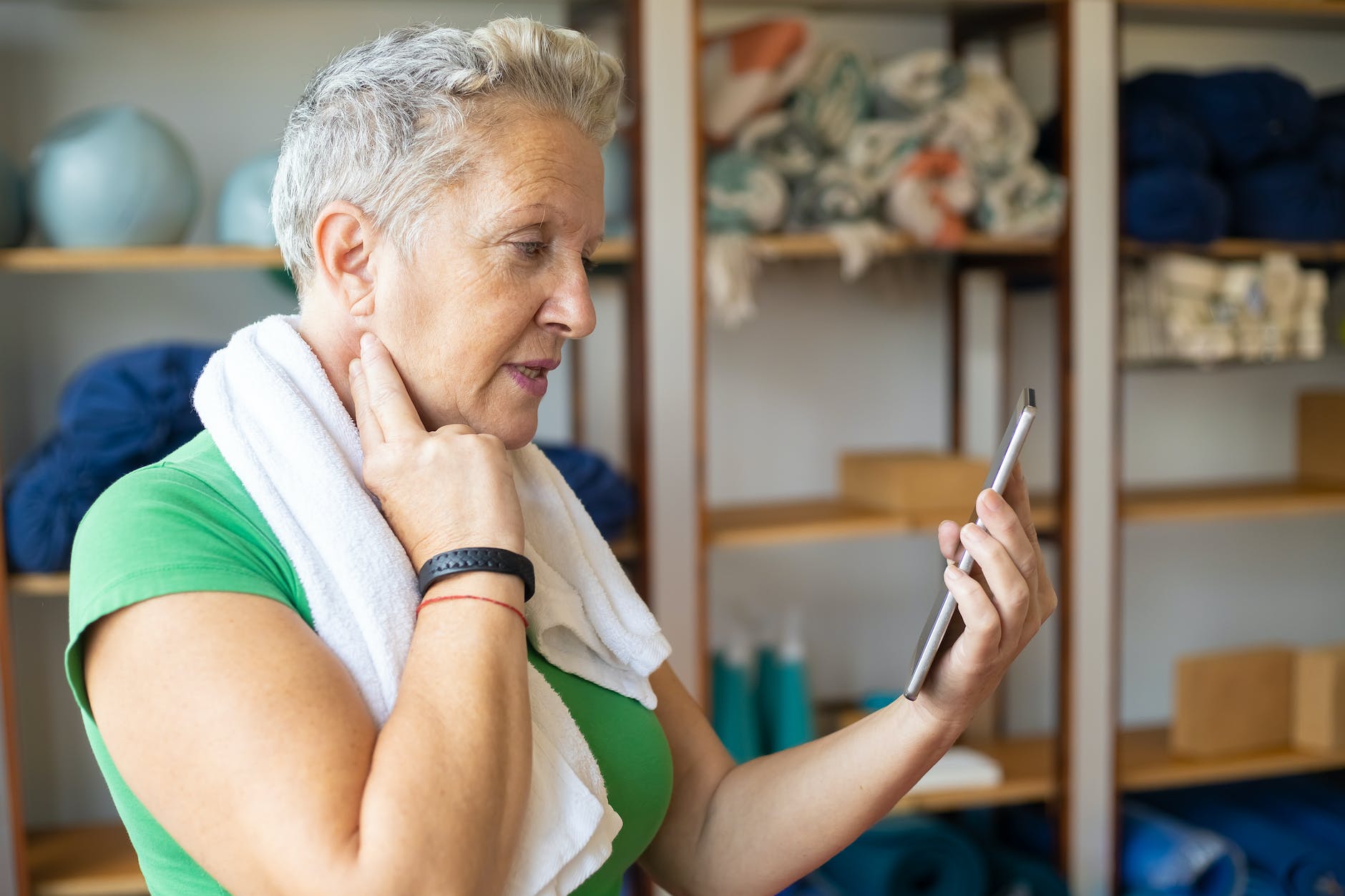 woman in green top holding a device