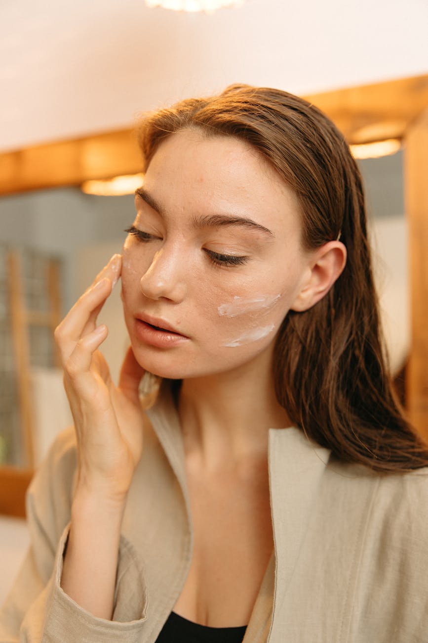 a woman applying cream on face