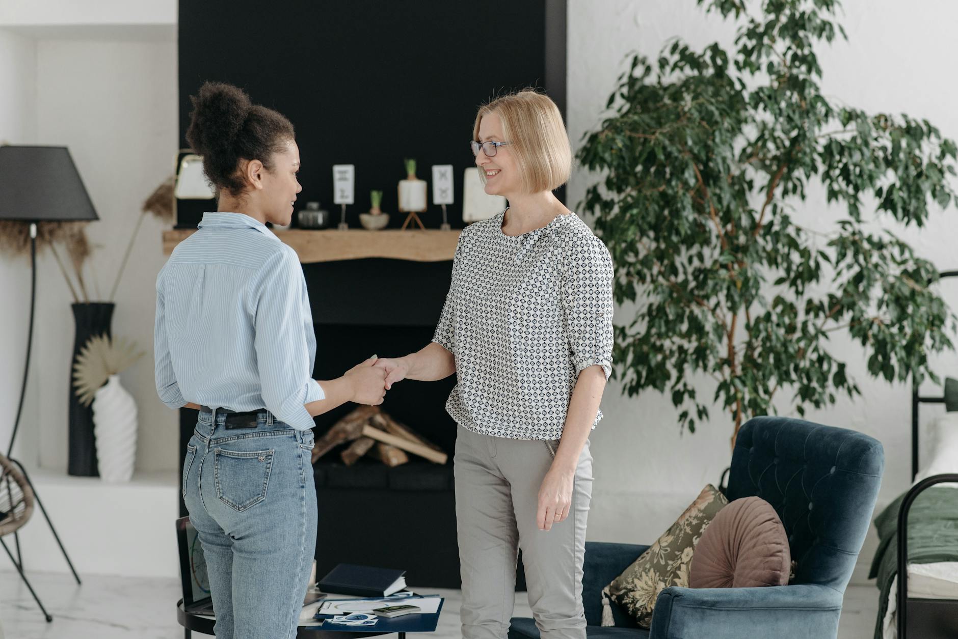 women shaking hands in a living room