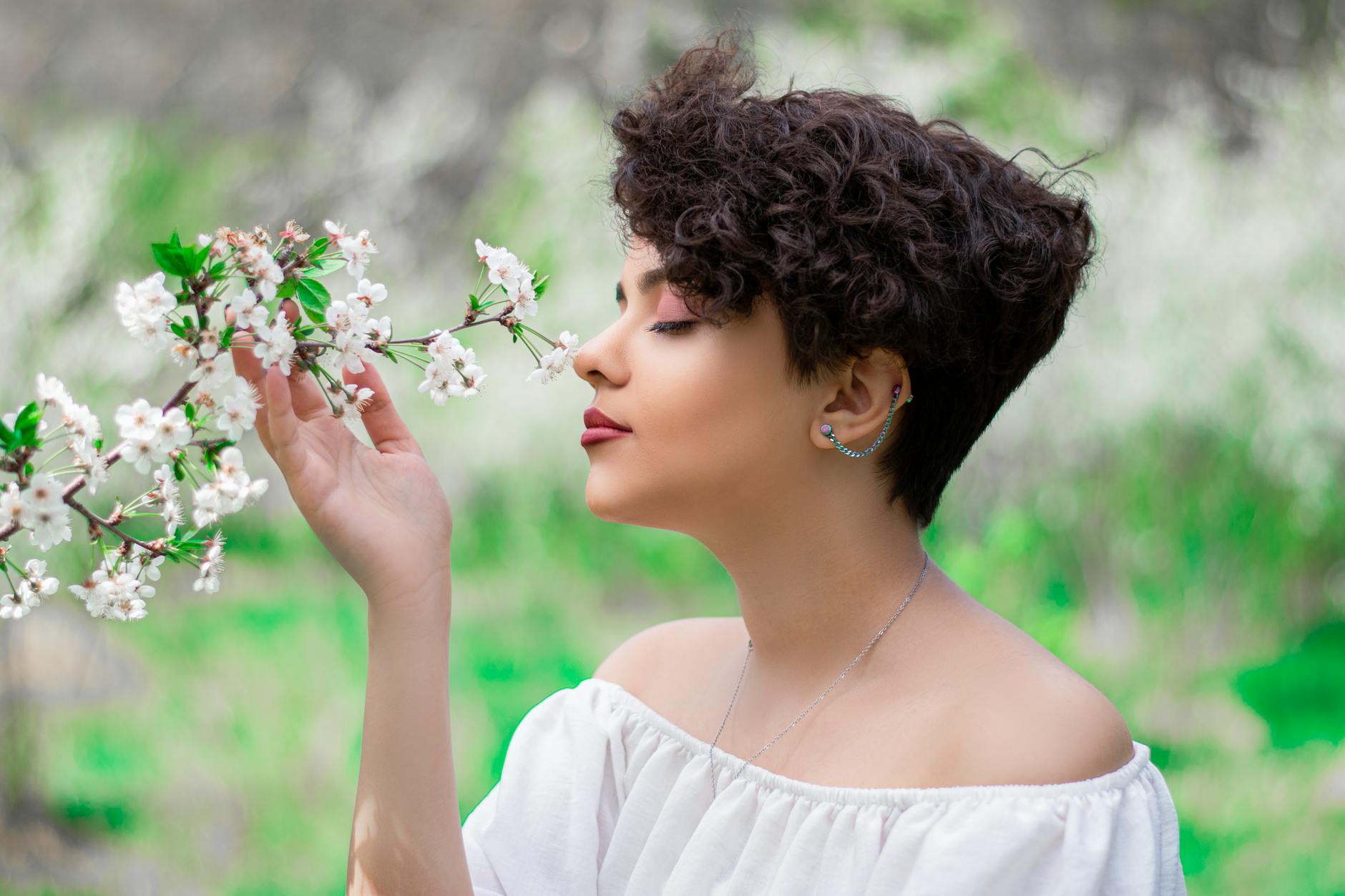woman in white shirt holding purple flowers